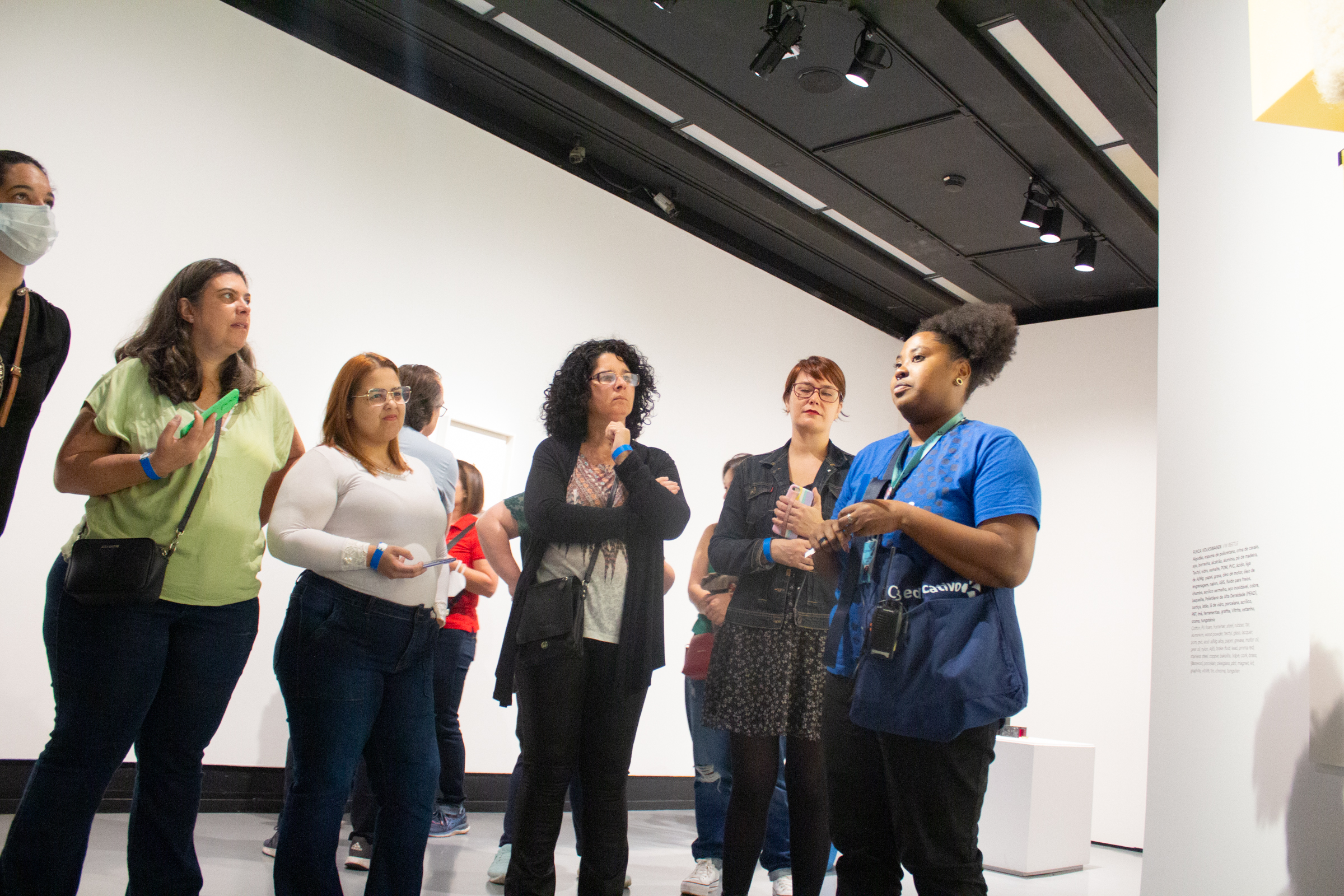 Foto colorida que mostra um grupo de educadoras em visita guiada à uma exposição no Centro Cultural Banco do Brasil.